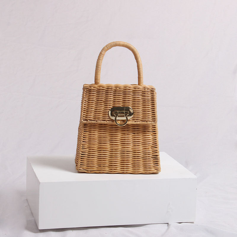 Katsura Woven Handbag — Rectangular woven handbag with an arched handle and front latch.