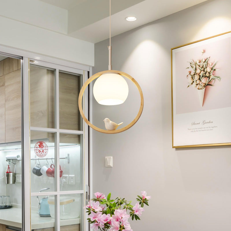 Jiaxing Pendant Light — Circular wooden ring pendant light with a glass globe.