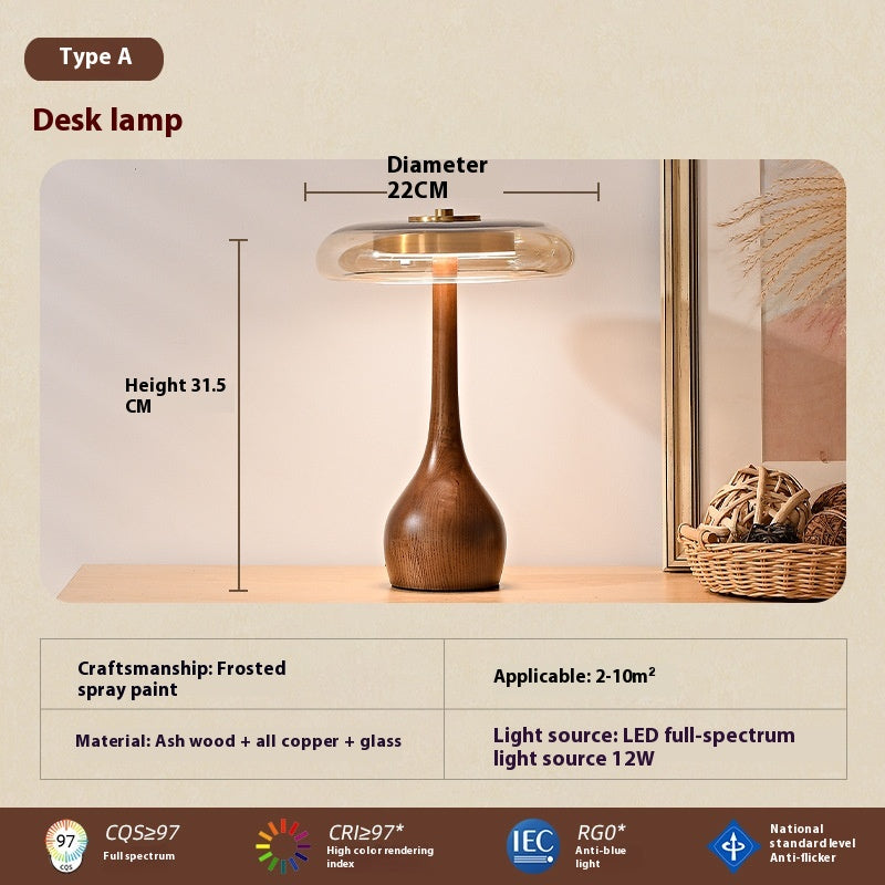 Daya Solid Wood Table Lamp — Table lamp with a sculpted ash-wood base and cognac-coloured glass shade.