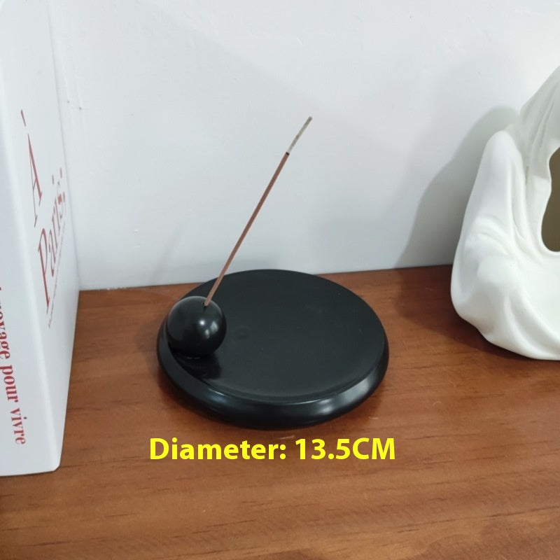 Kupang Incense Holder — Black circular ceramic incense plate with a raised stick holder.
