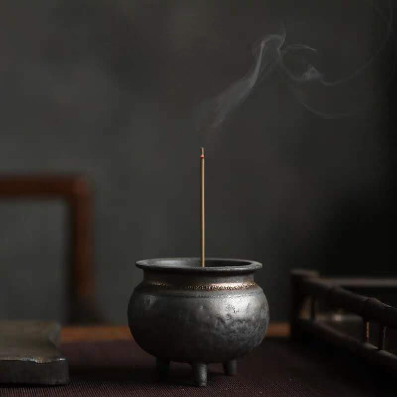 Ambon Incense Burner — Three-legged ceramic incense burner with a bronze-toned finish and decorative lid.