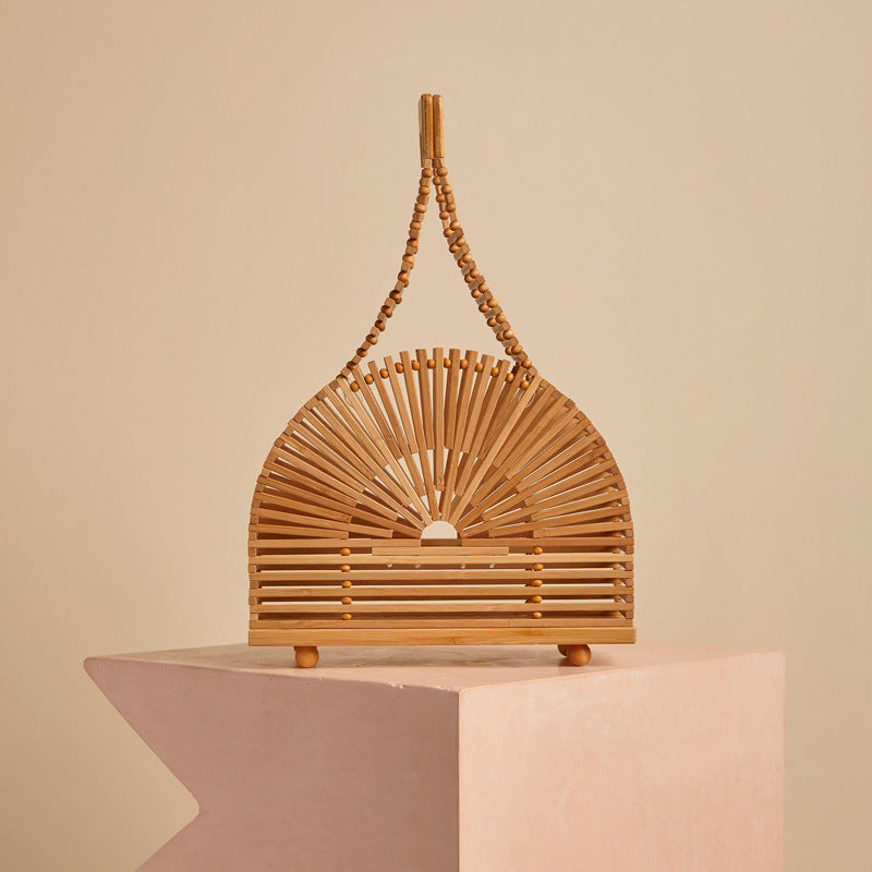 Liangxi Wooden Slat Handbag — Semicircular slatted wooden handbag with long woven handles.